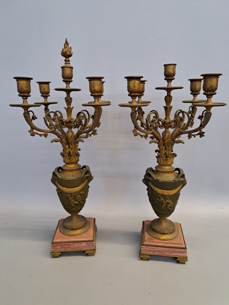 Coppia di candelieri, bronzo dorato,con vasi a balaustro decorati con putti, basi in marmo rosa