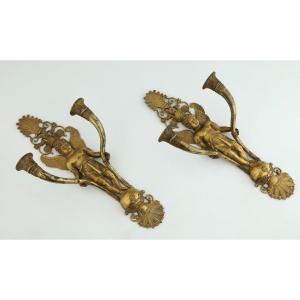COPPIA DI APPLIQUE Impero, in bronzo  dorato decorato con putti che sorreggono due bracci, XIX 