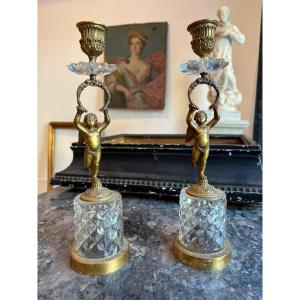 Coppia di candelieri in bronzo dorato e cesellato con putti alati