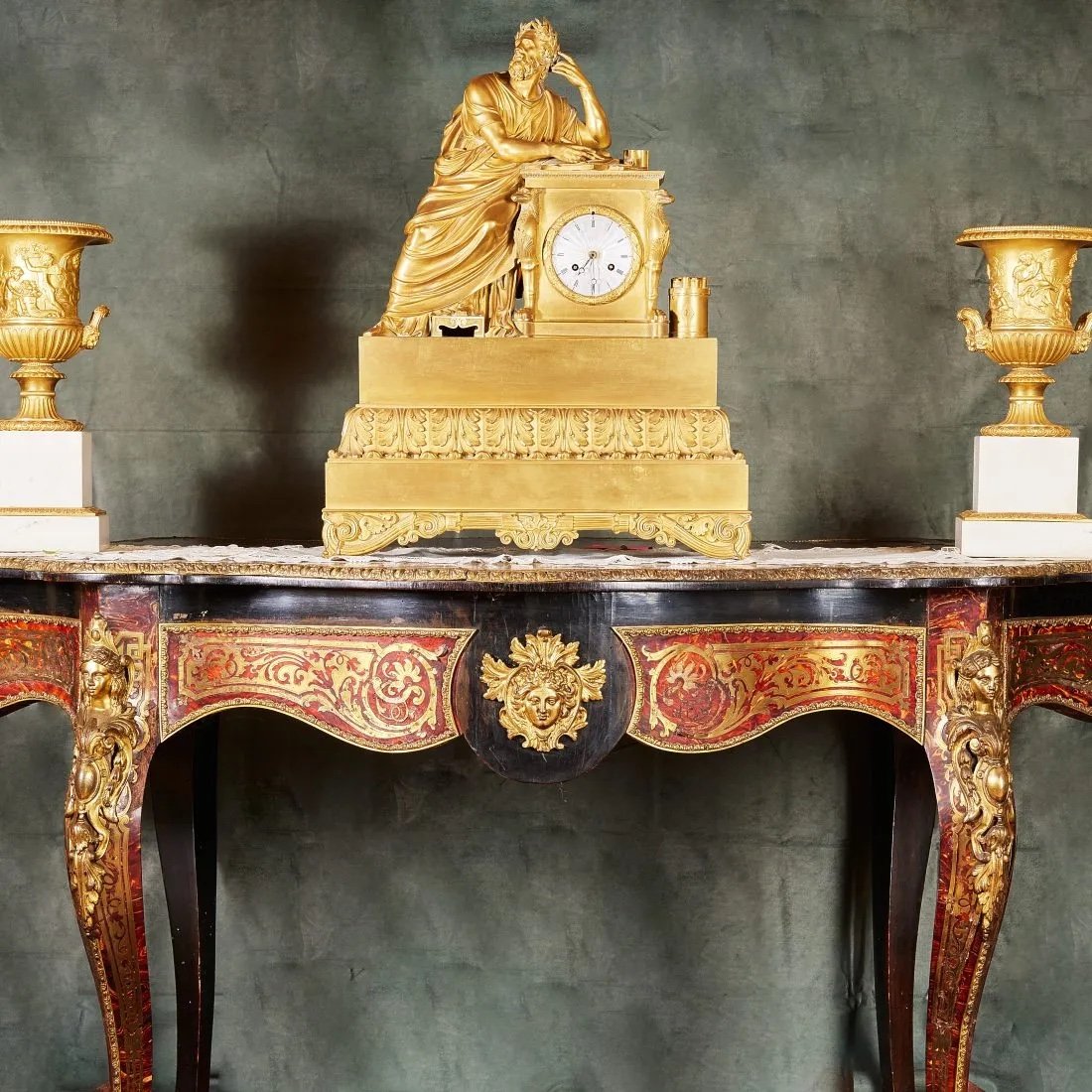 Importante trittico in bronzo dorato composto da pendola raffigurante Omero, due imponenti vasi