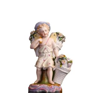 Gruppo in porcellana policroma. Putto con ceste di fiori. Germania, fine del XIX SECOLO. 