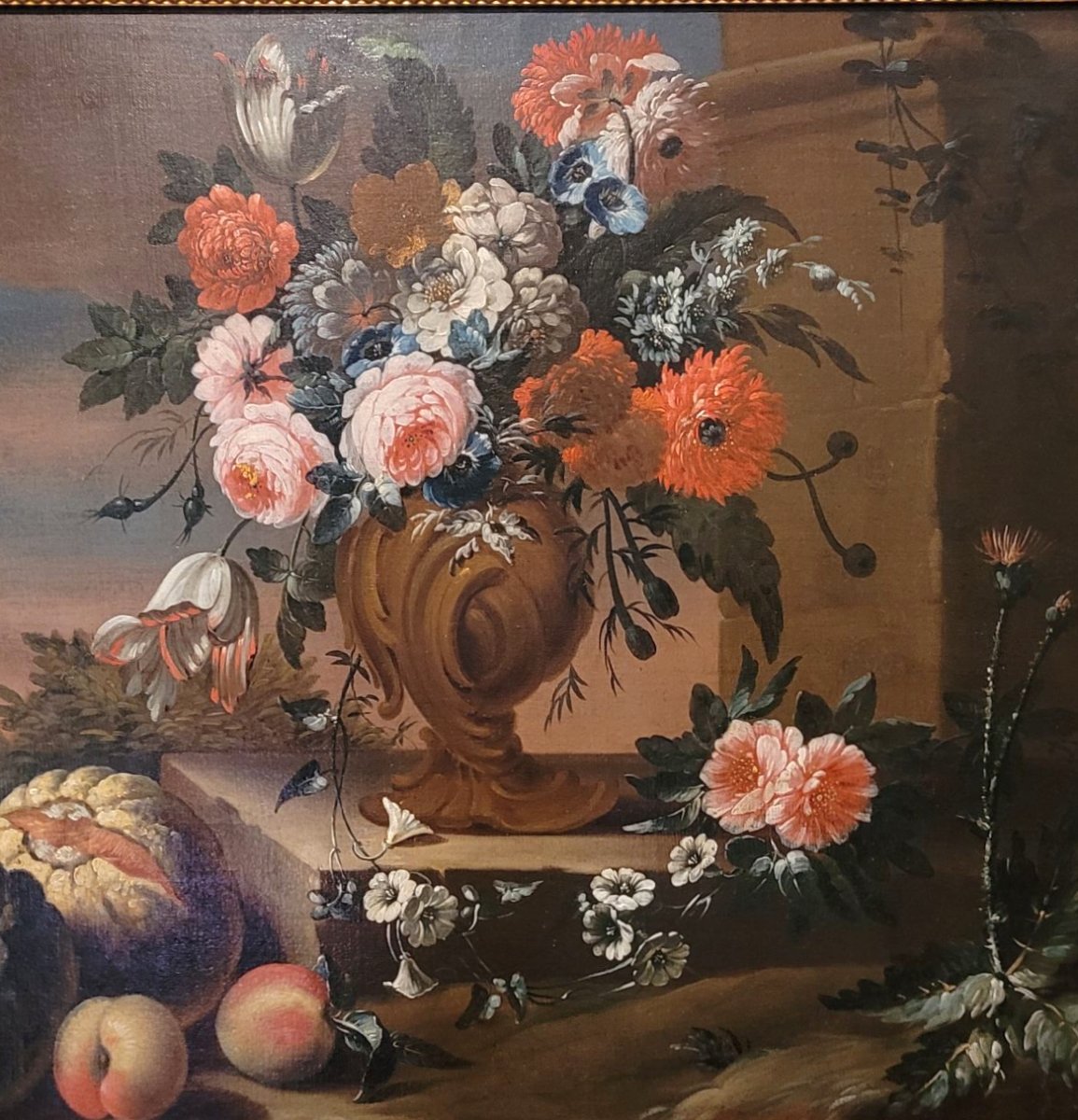 Natura morta con vaso di fiori, zucca e frutta in un paesaggio”-photo-3