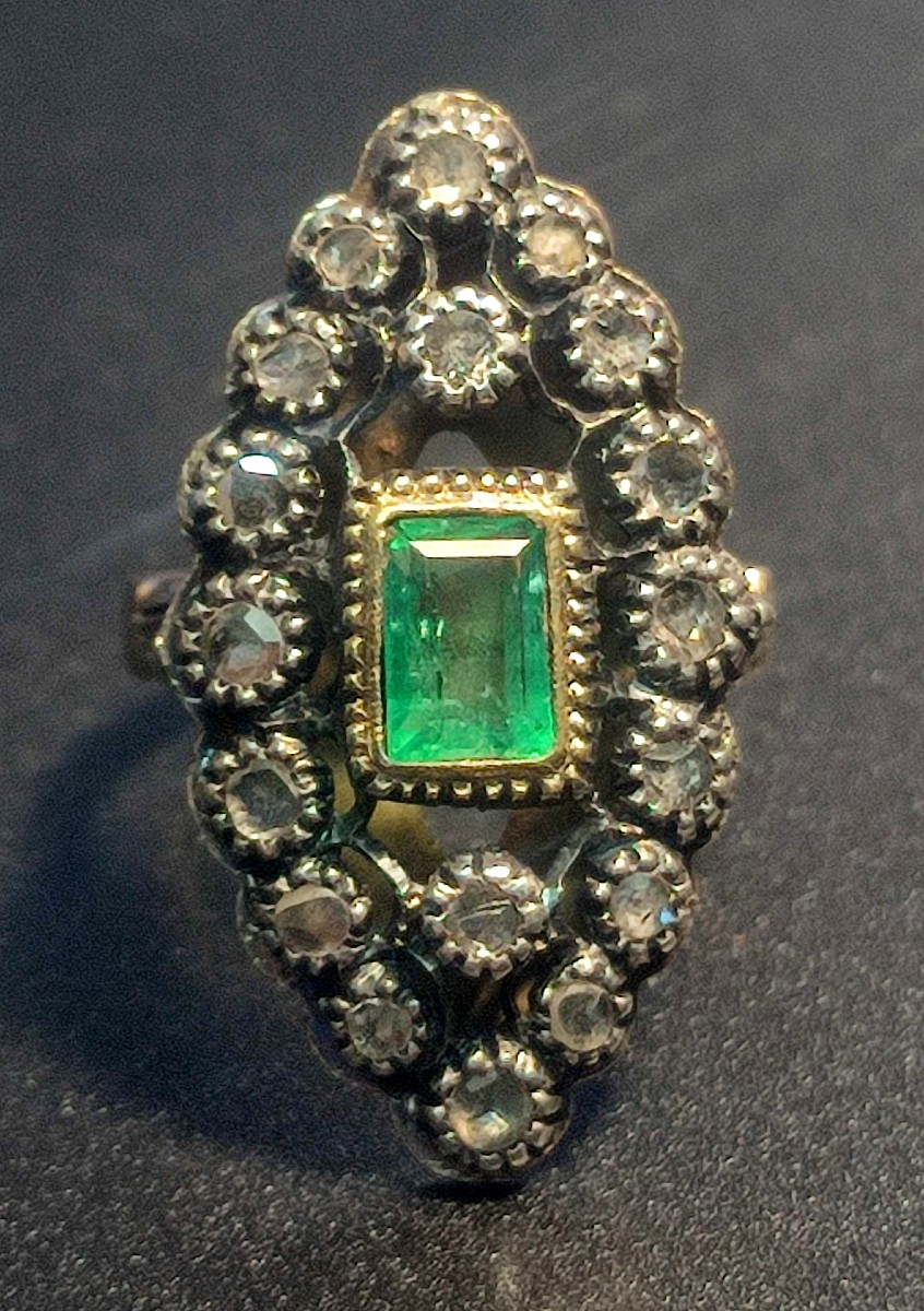 Anello a spoletta in oro con smeraldo kt.1,05 e rose di diamante kt. 035 circa. Peso gr.6,2. 