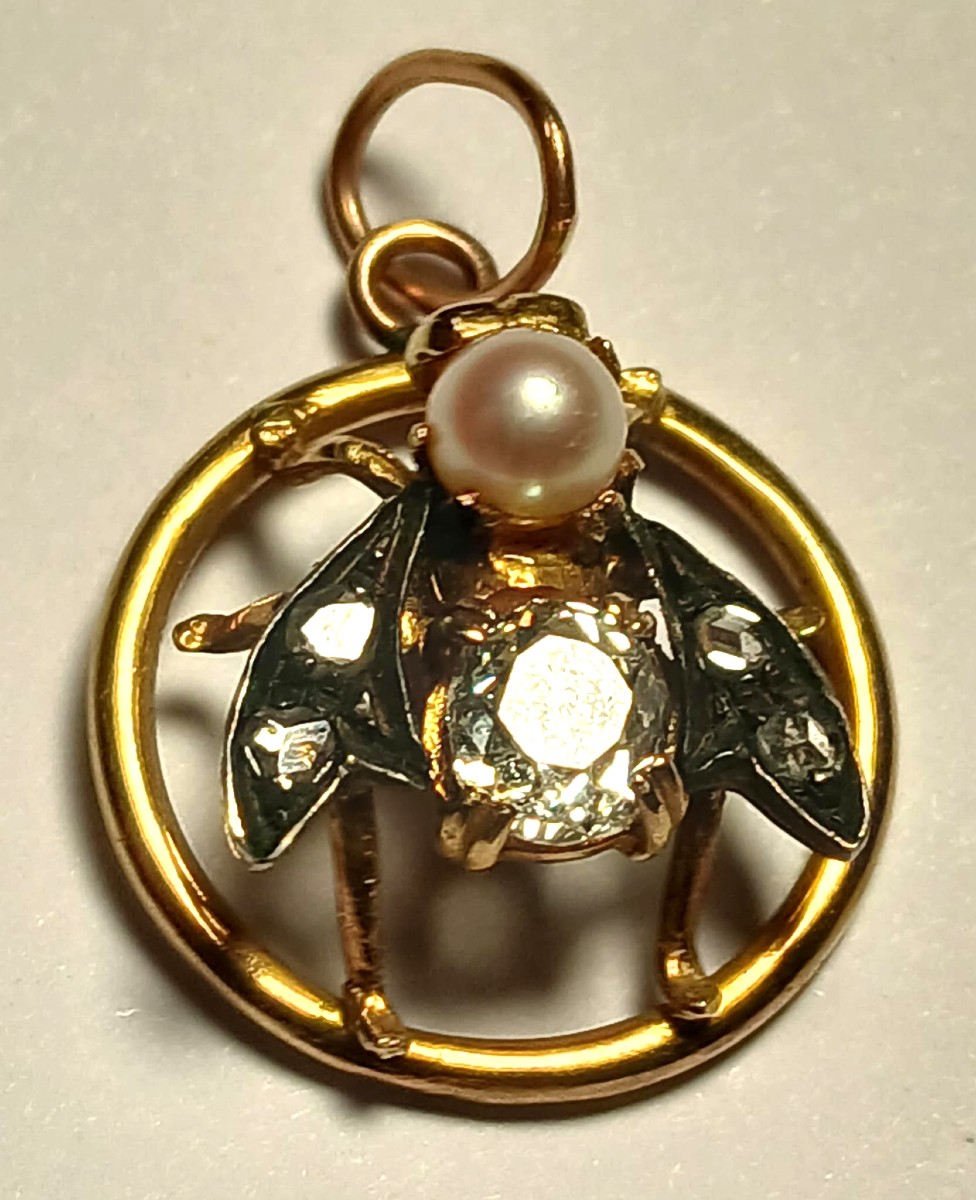 ìLa Mosca'. Pendente in oro con brillante taglio antico bianco  0,75 e perlina con diamanti.