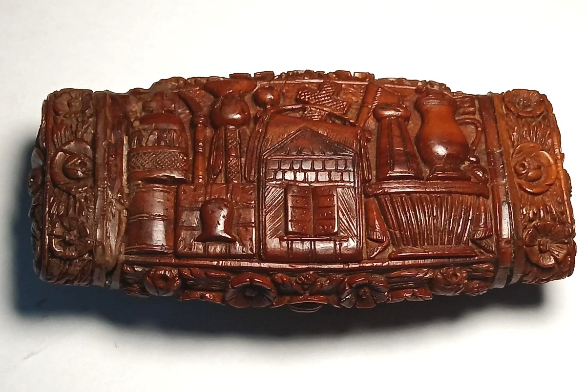 Tabacchiera scolpita in 'corozo' con raffigurazione di oggetti sacri e curiosi. Francia 1830 c.