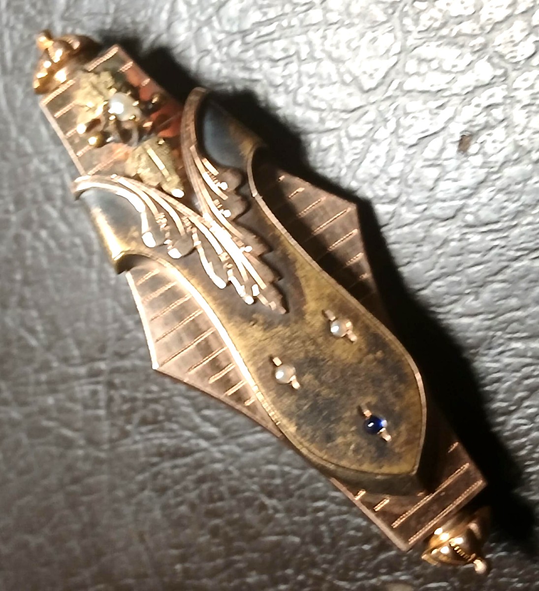 Spilla borbomica in oro 14 kt. con festone fogliaceo su fondo rigato.  -photo-3