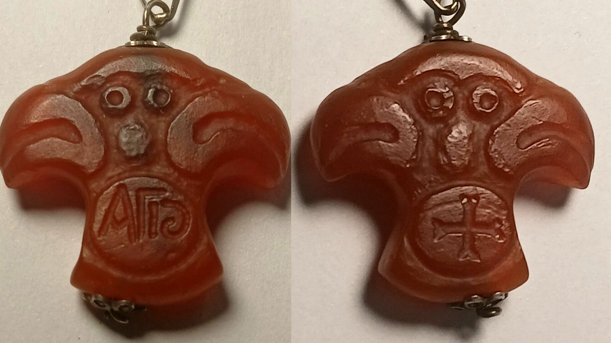 Amuleto Templare in corniola scolpita, raffigurante una croce composta da due teste d' aquila