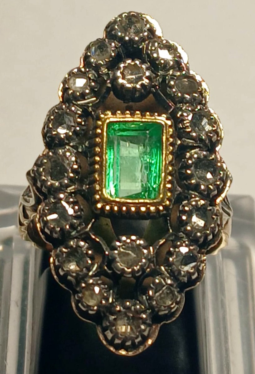 Anello in oro e coppella, con smeraldo di kt.1,10 circondato da rose di diamante kt.0,60.