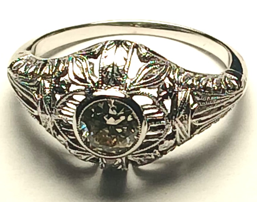  Brillante solitario di Kt. 0,50, su montatura liberty traforata a motivi fogliacei.-photo-4