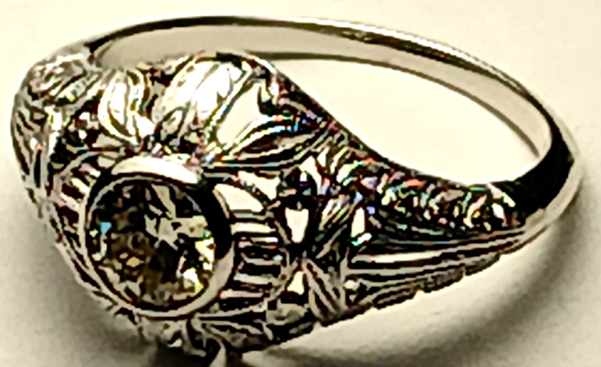  Brillante solitario di Kt. 0,50, su montatura liberty traforata a motivi fogliacei.