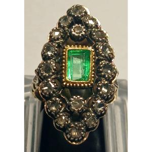 Anello in oro e coppella, con smeraldo di kt.1,10 circondato da rose di diamante kt.0,60.