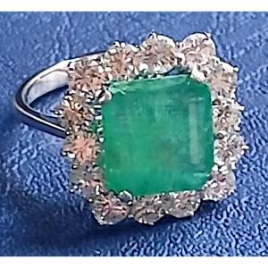 Anello con smeraldo di carati 4 e brillanti carati 2,10 entro montatura in oro bianco, 1960/70.