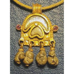 Amuleto'Magico' in oro zecchino e quattro piccoli bezoari pendenti. Bisanzio sec.X-XII circa.