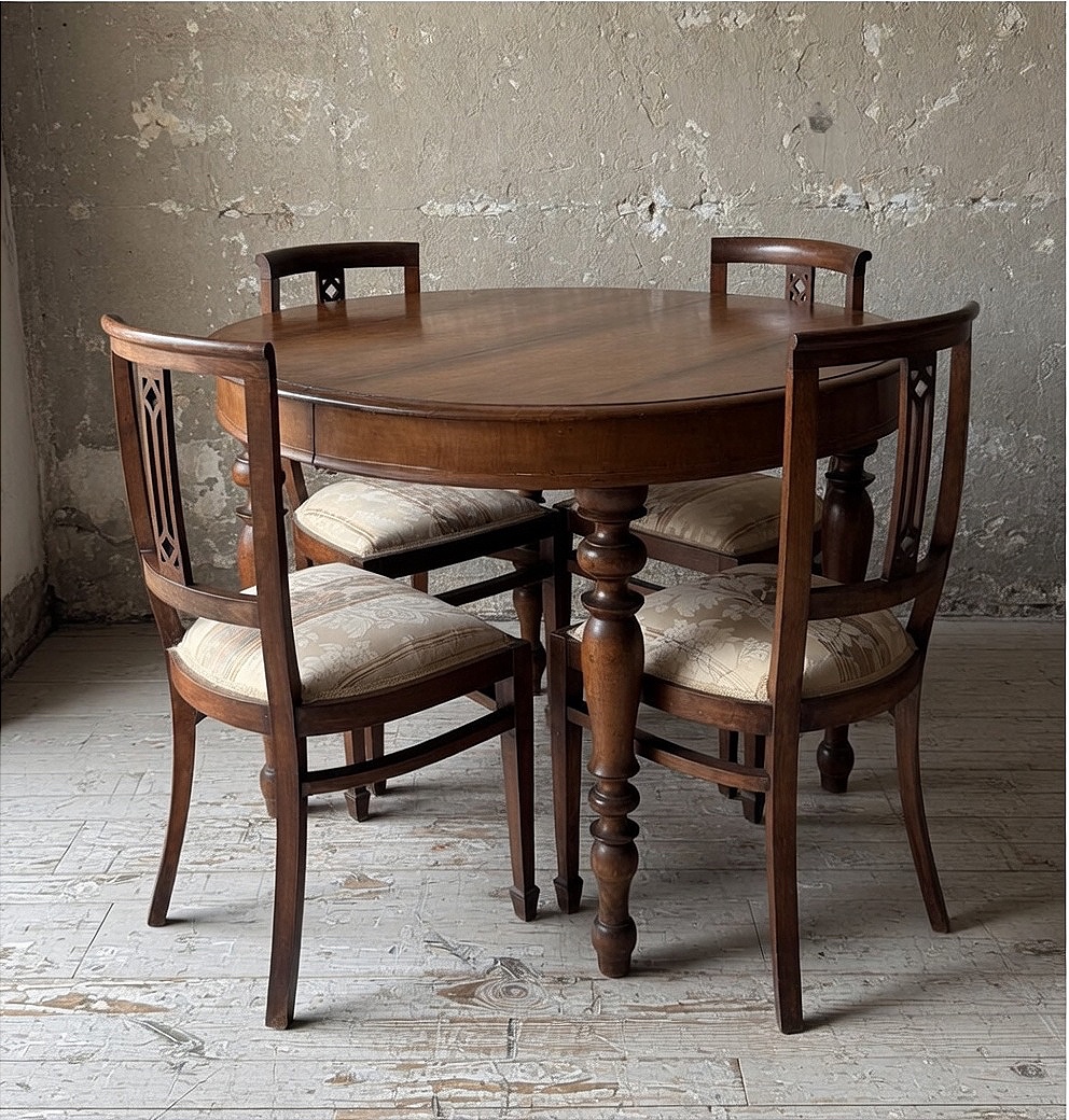 Tavolo rotondo allungabile con prolunghe originali e quattro sedie coordinate.