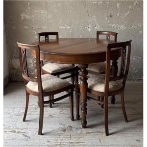 Tavolo rotondo allungabile con prolunghe originali e quattro sedie coordinate.