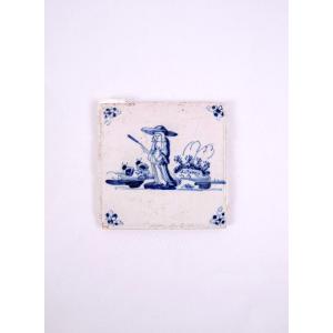 18th-century Delftware Tile Depicting A Peasant Woman With A Stick, Facing Forward