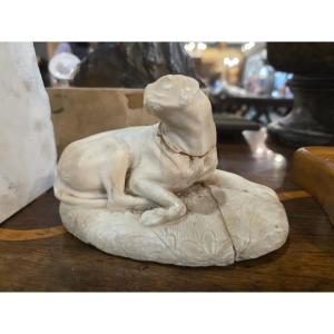 Piccola scultura in marmo raffigurante un cane sdraiato. Italia XVIII