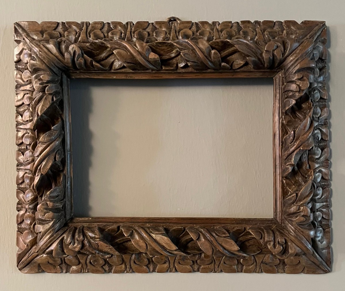Cornice in noce, legno scolpito e intagliato.