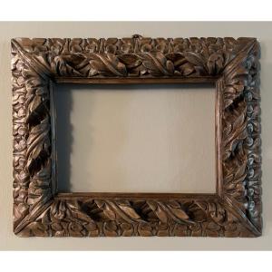 Cornice in noce, legno scolpito e intagliato.