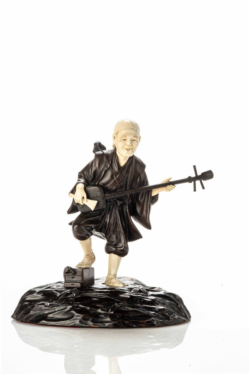 Okimono in bronzo e avorio raffigurante un intrattenitore di strada mentre suona il shamisen