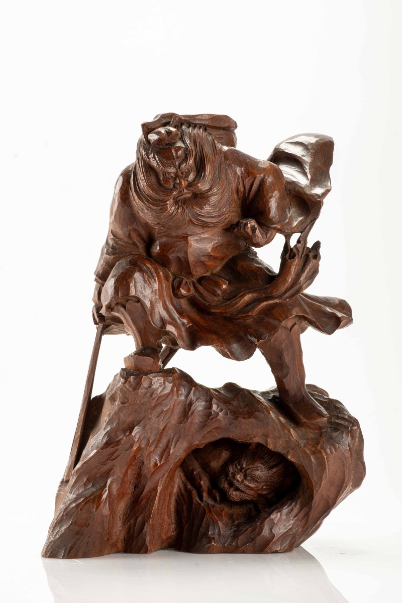 Okimono in legno di bosso raffigurante Shōki intento a sorprendere un oni