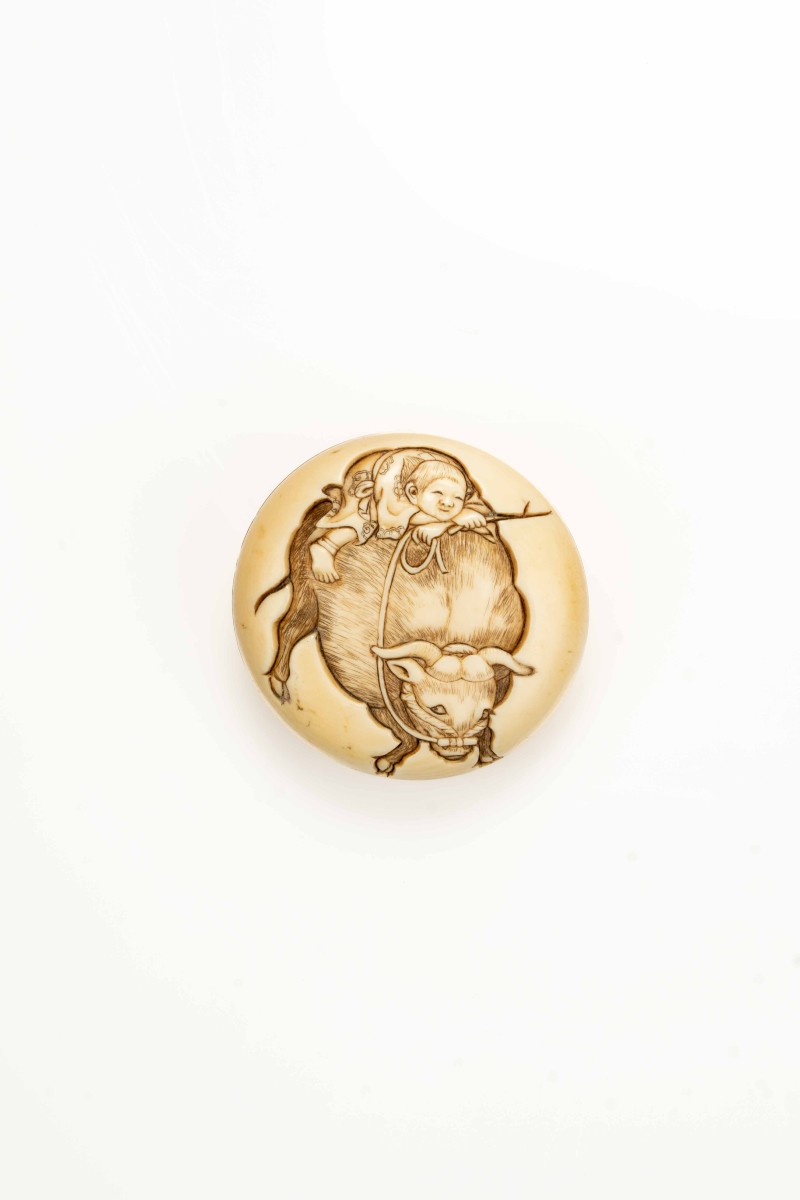 Netsuke giapponese manju in avorio raffigurante Kintaro su un bufalo, firmato Ipposai