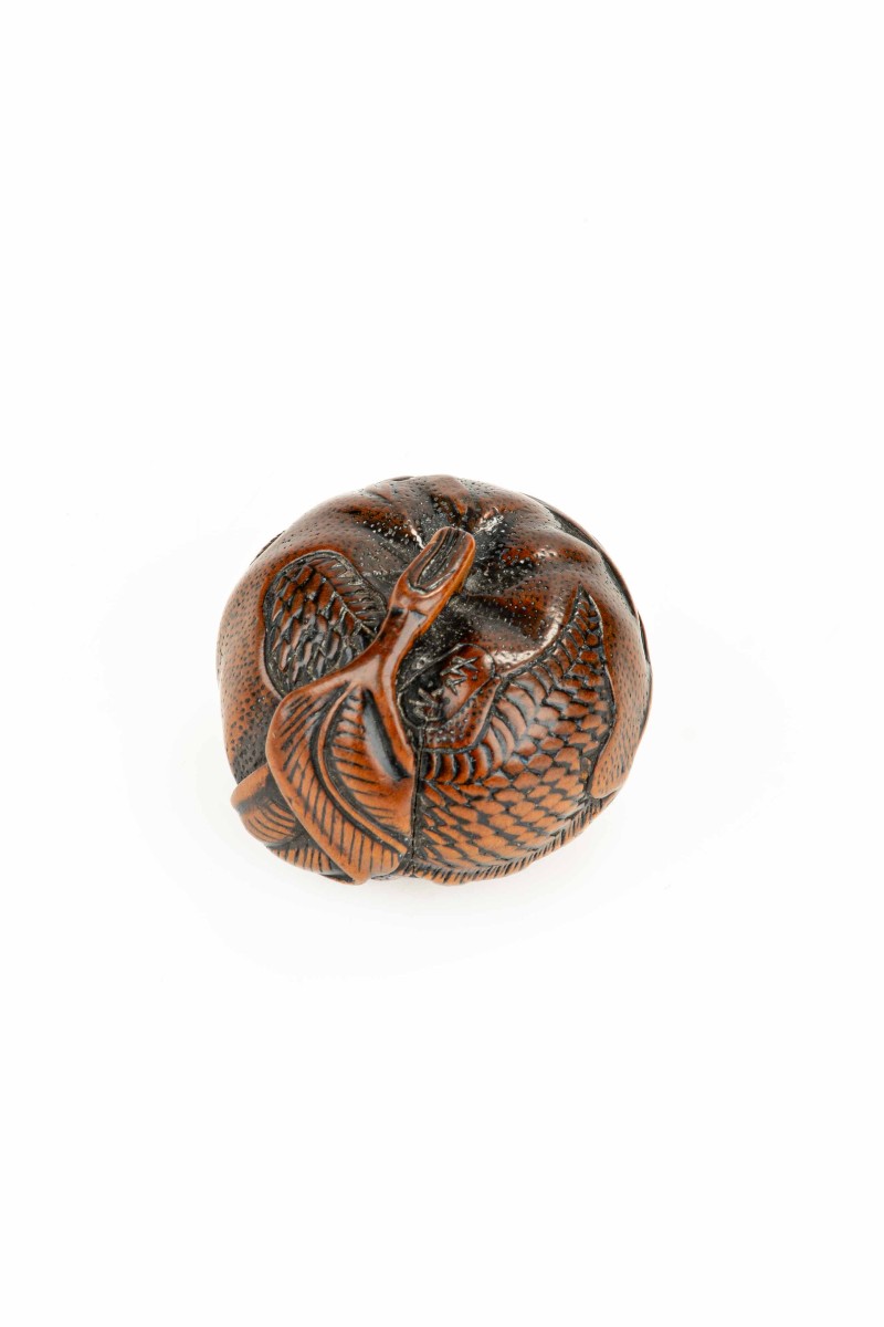 Netsuke in legno di bosso raffigurante un mandarino con drago inciso, firmato Tomomitsu