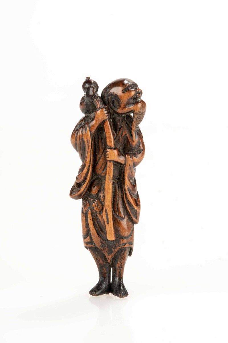 Netsuke in legno di bosso raffigurante un Sennin con bottiglia di sakè