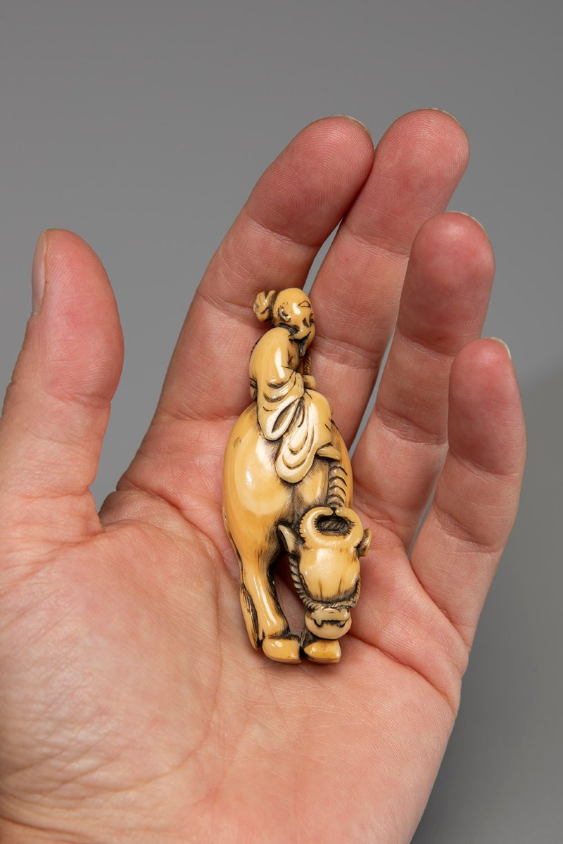 Netsuke in avorio raffigurante Roshi seduto sul dorso di un bufalo-photo-1