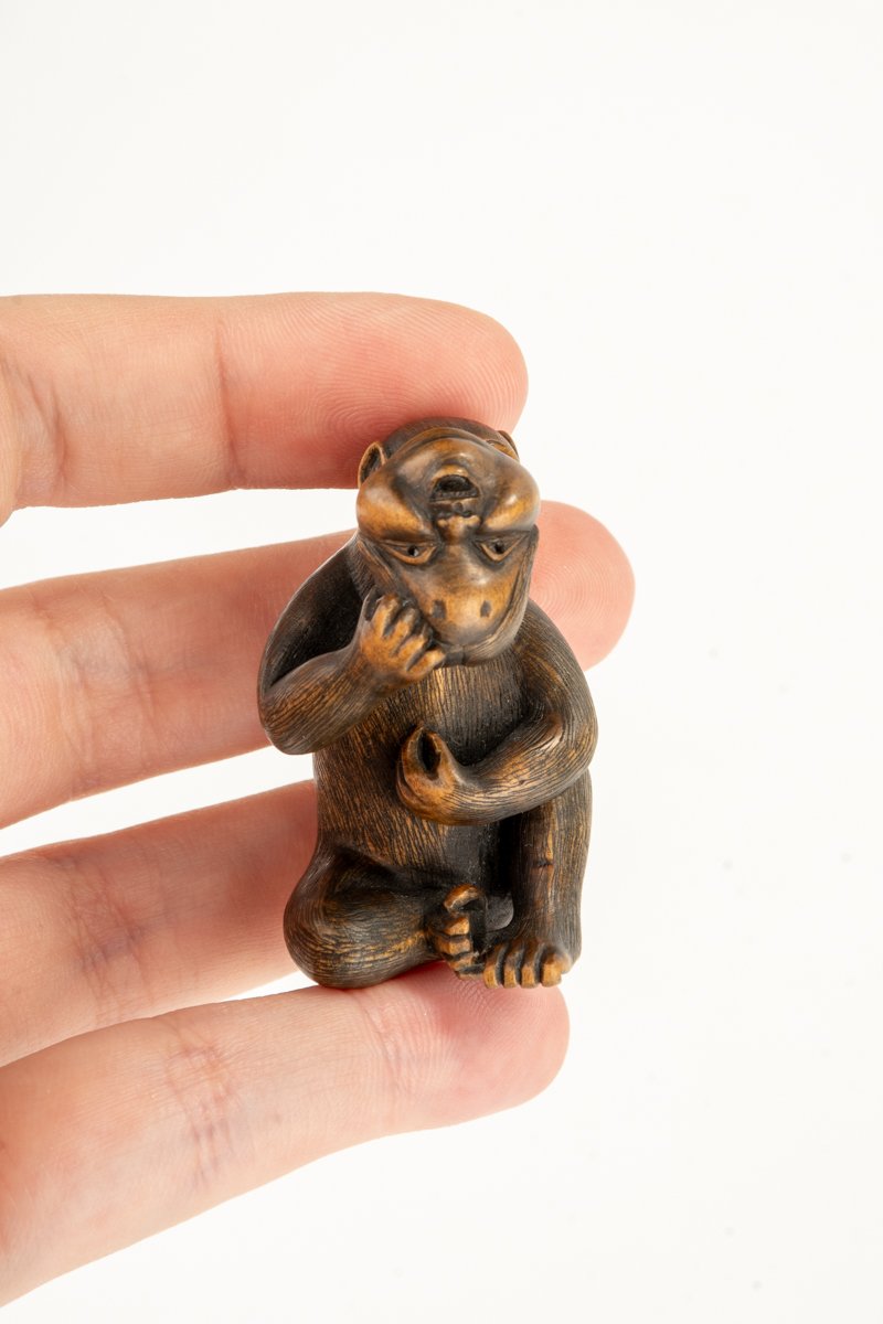 Netsuke in bosso raffigurante una scimmia con la maschera di Okame, firmato Shinzan-photo-1