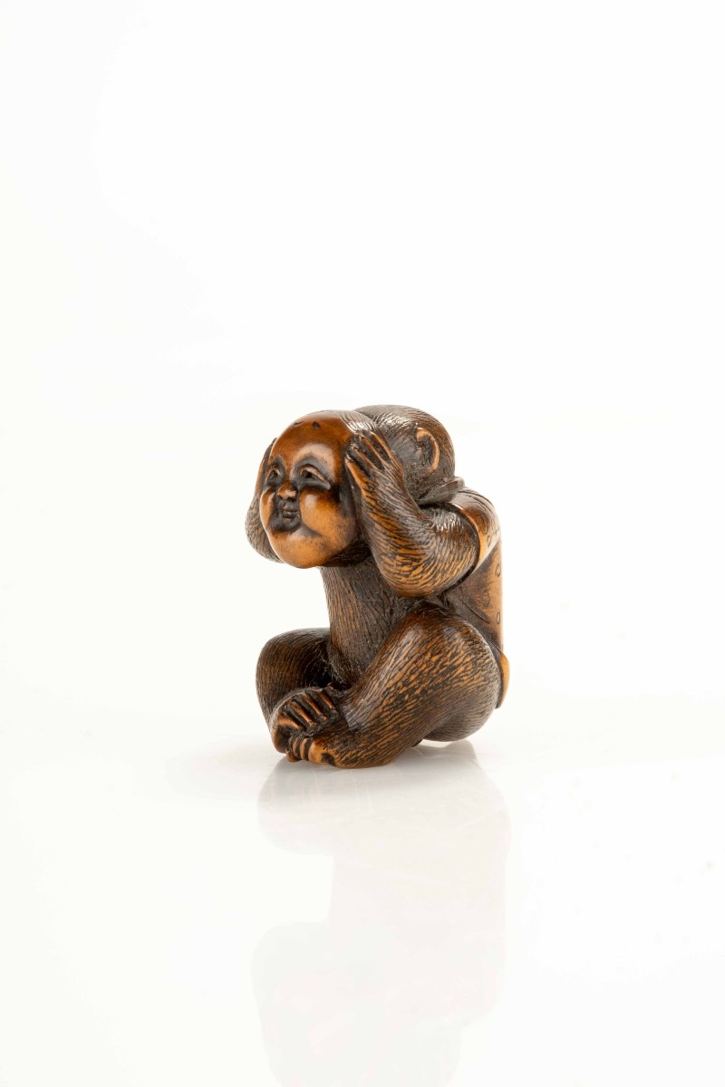 Netsuke in bosso raffigurante una scimmia con la maschera di Okame