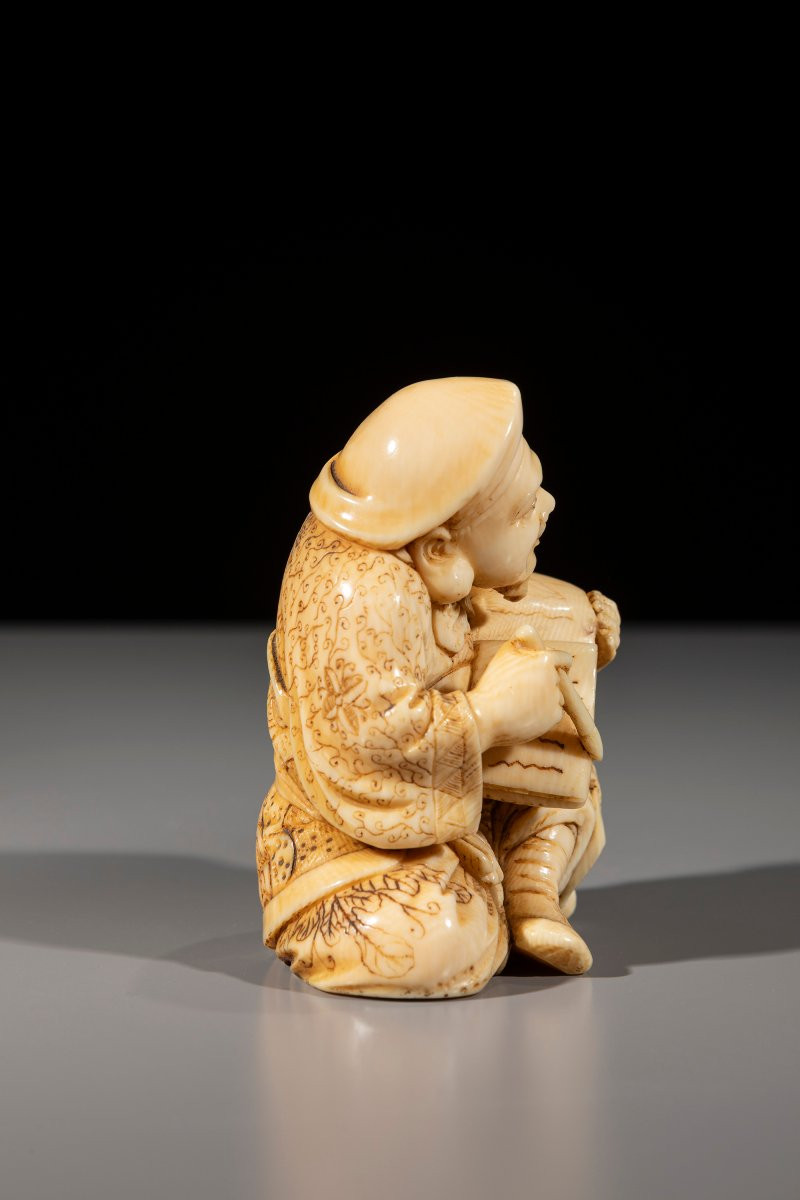 Okimono in avorio raffigurante Daikoku con pennello e libro-photo-1