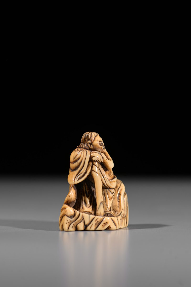 Netsuke in avorio raffigurante Rakan su una roccia-photo-1