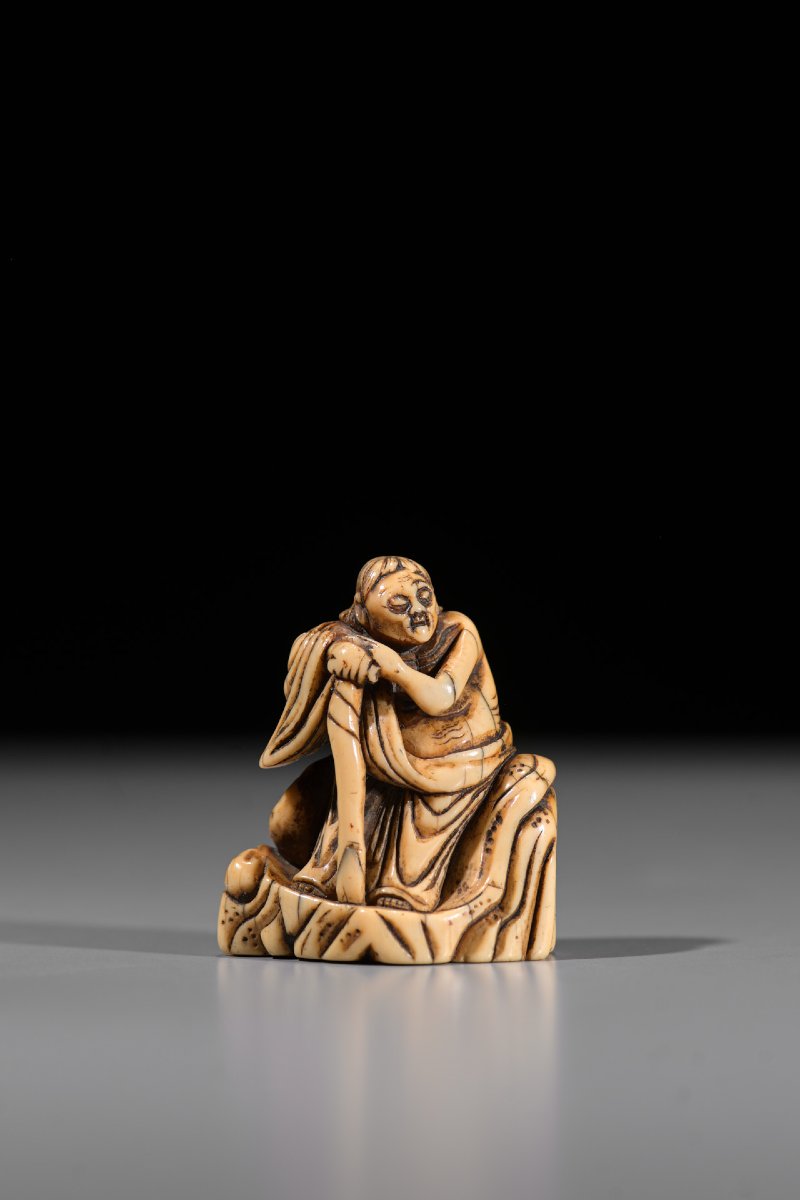 Netsuke in avorio raffigurante Rakan su una roccia