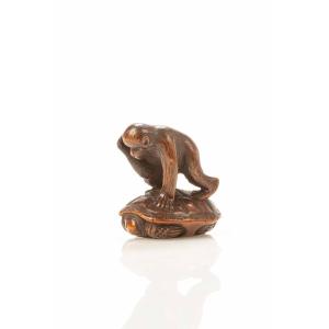 Netsuke in legno di bosso che raffigura una scimmia che cerca di catturare una tartaruga