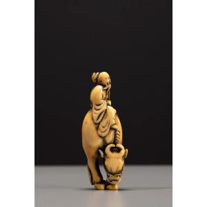 Netsuke in avorio raffigurante Roshi seduto sul dorso di un bufalo