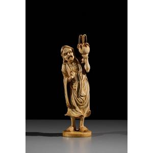Okimono in avorio raffigurante Rakan con un vaso rituale, firmato Kazutoshi