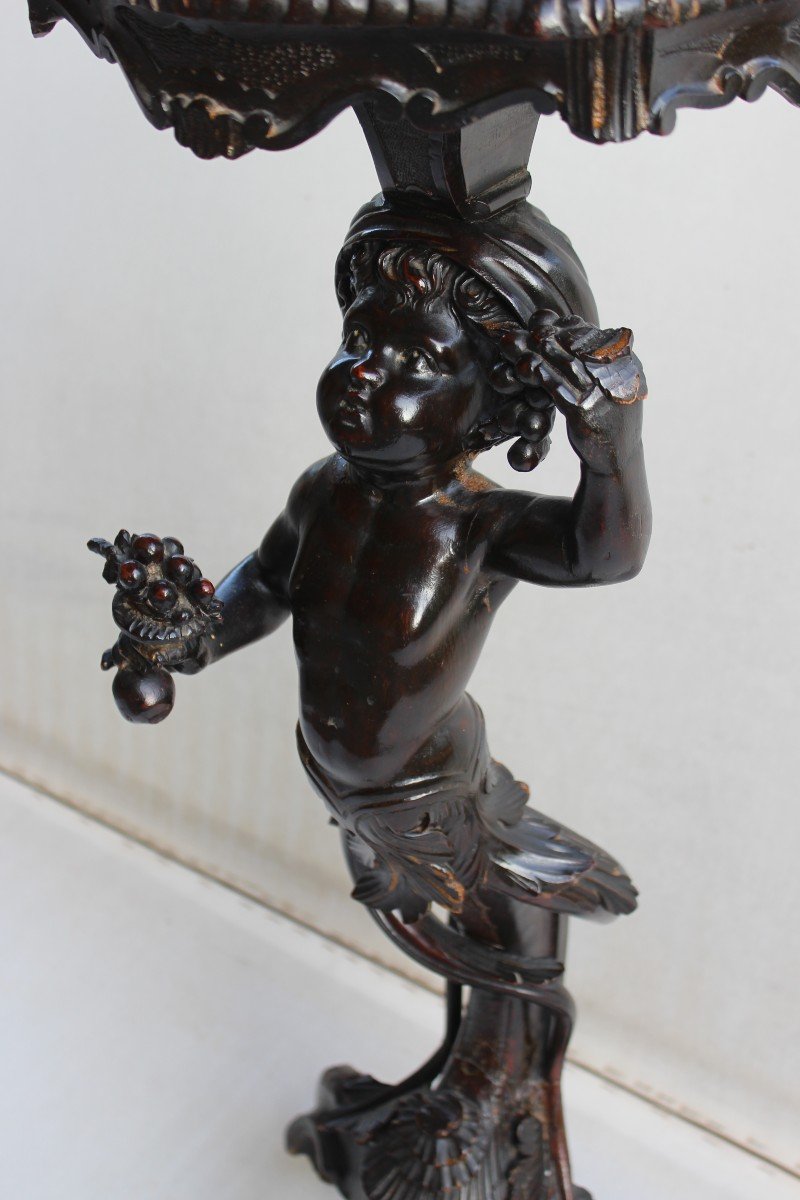 TRESPOLO IN LEGNO INTAGLIATO "PUTTO", ITALIA FINE XIX SECOLO.