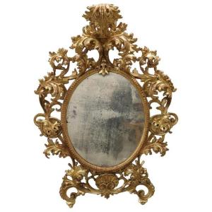 Specchio antico ovale in legno intagliato e dorato, XVIII secolo