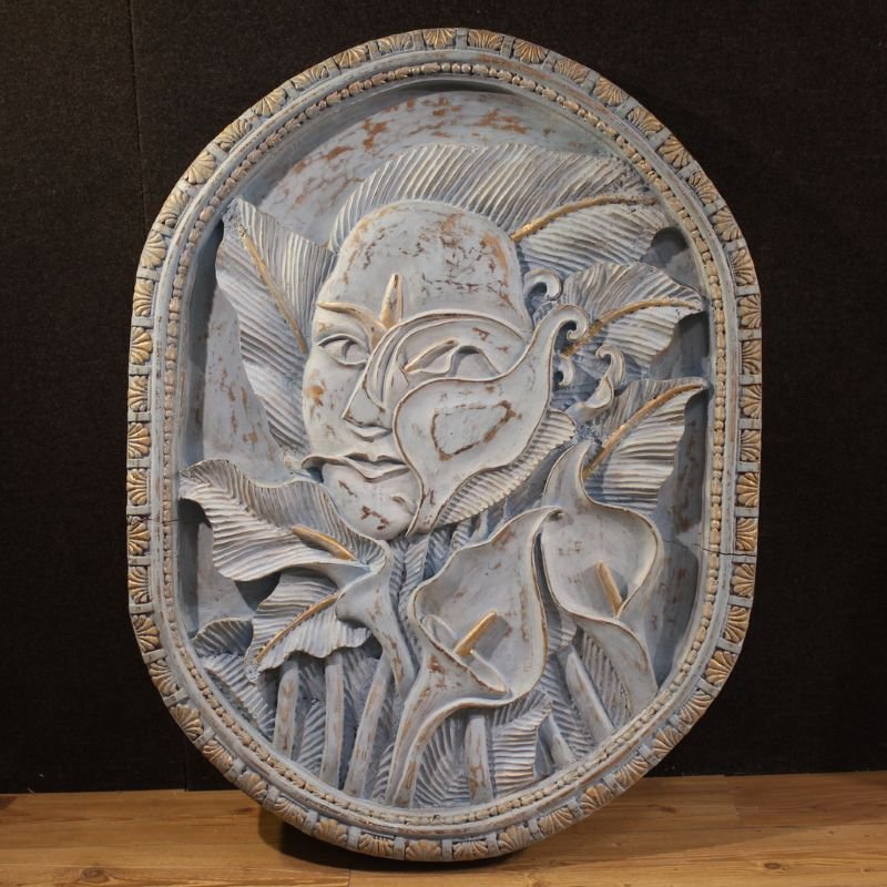 Scultura bassorilievo, volto stilizzato con fiori, XX secolo