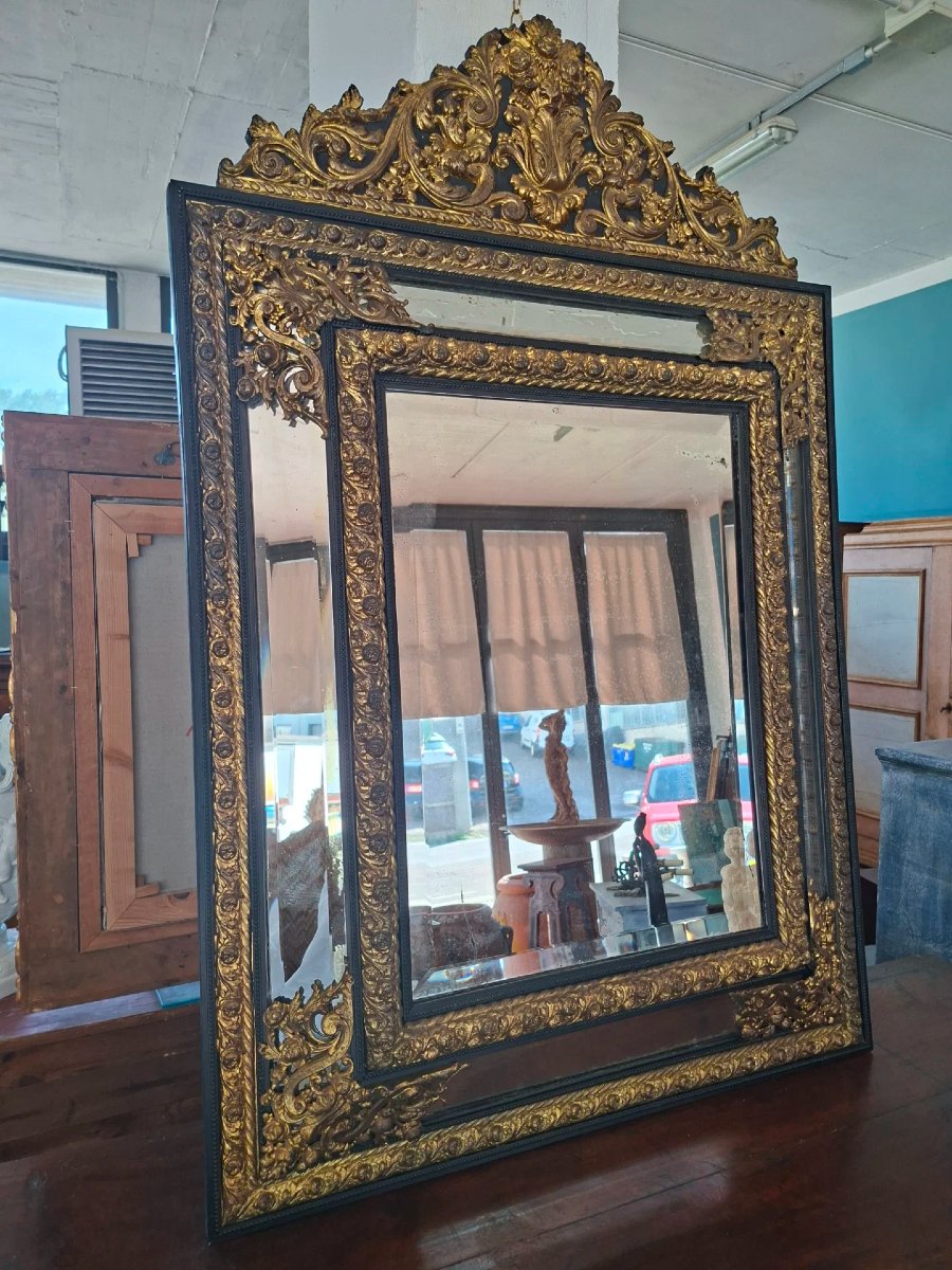 Specchiera in legno ebanizzato e metallo sbalzato
