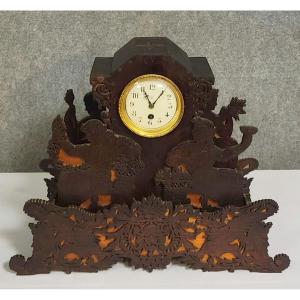 A "black Forest" Clock Made Of Finely Openwork Wood, Depicting Two Sculpted Figures.