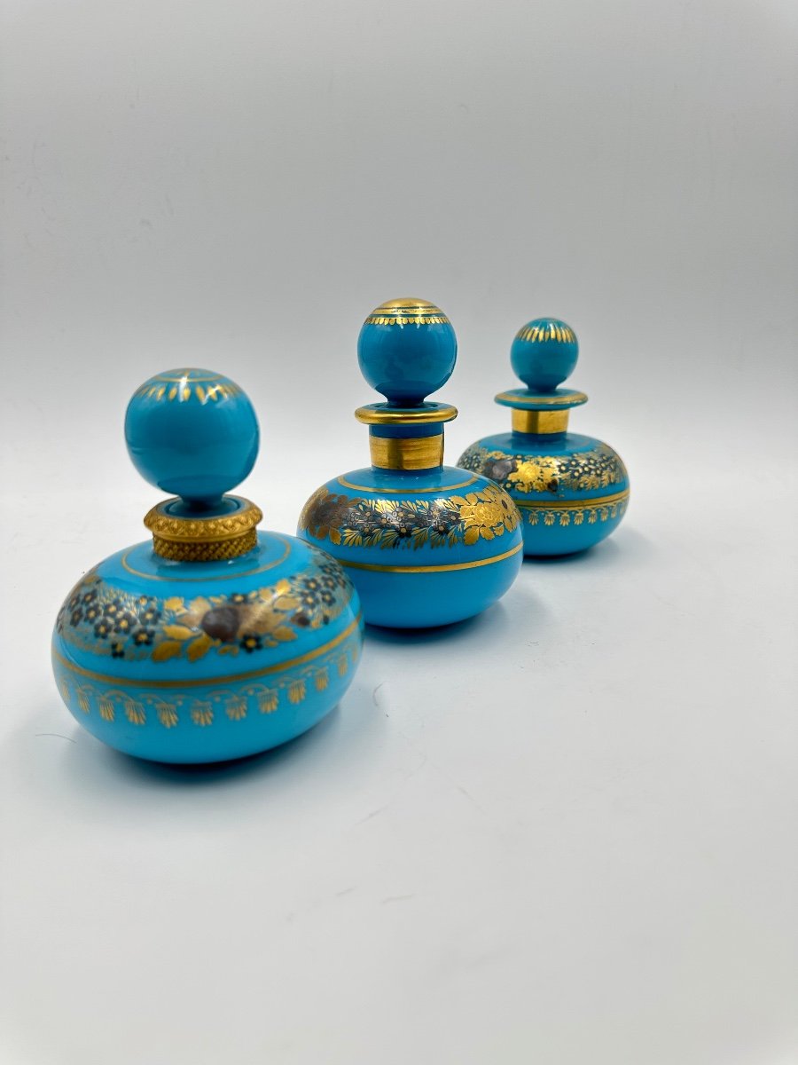 Set di tre bottiglie opaline blu turchese con decorazione dipinta di fiori dorati.-photo-3
