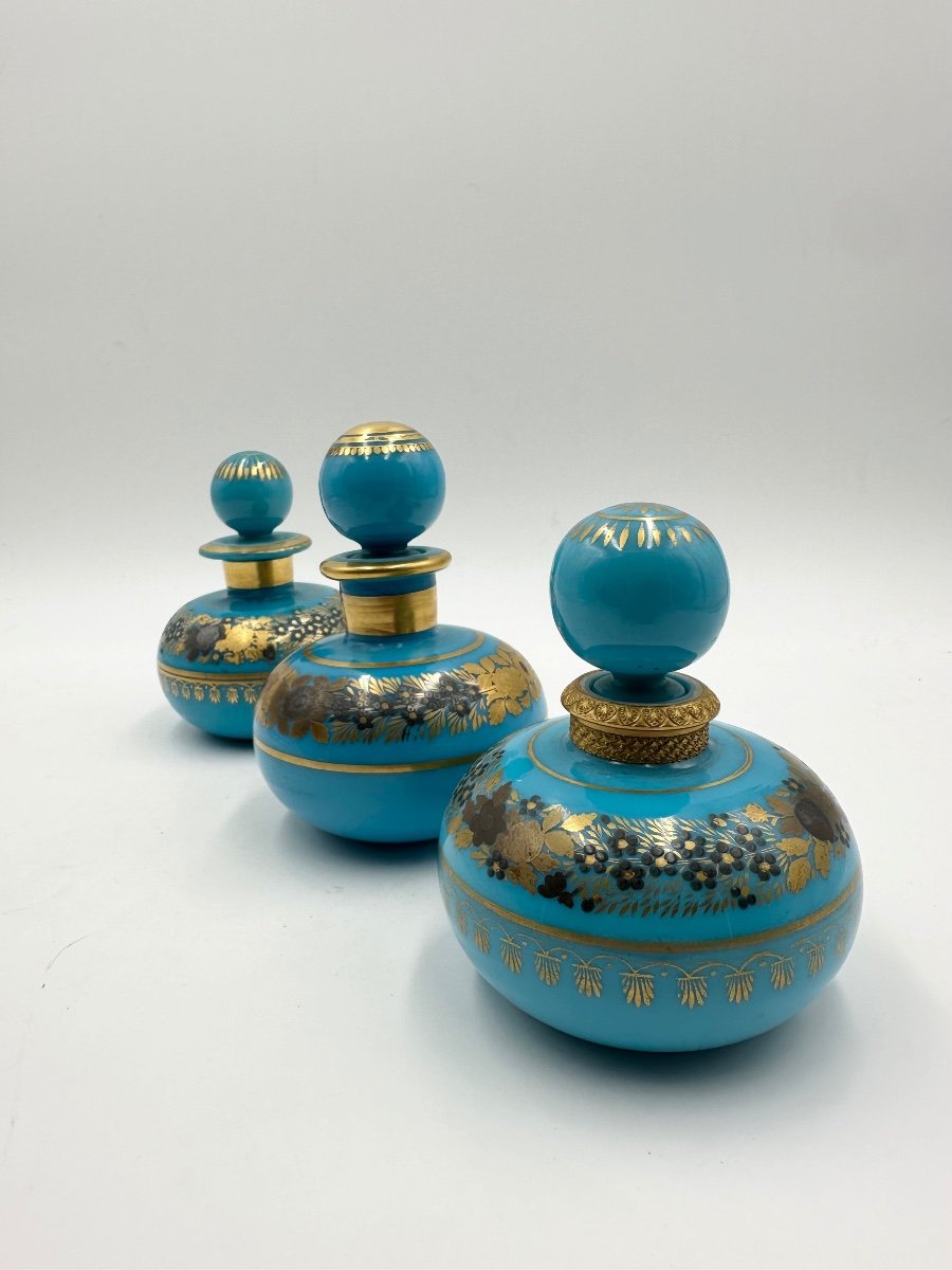 Set di tre bottiglie opaline blu turchese con decorazione dipinta di fiori dorati.-photo-4
