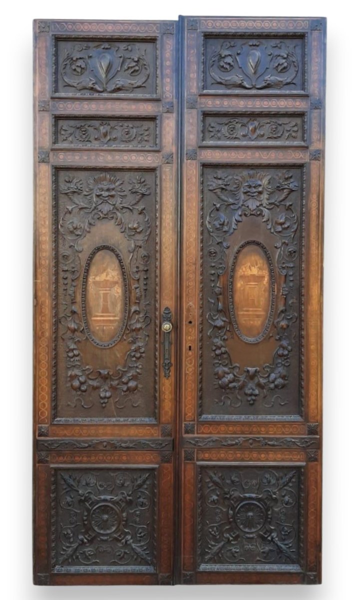 Porta in noce, due battenti scolpiti con mascheroni e decori fogliacei, epoca '800