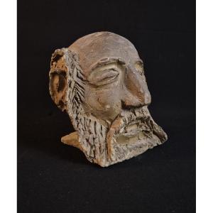 Sculpture Of A Bearded Man's Head In Raw Clay
