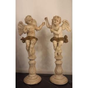 Coppia di angeli alati in legno laccato, seduti, del XVIII secolo