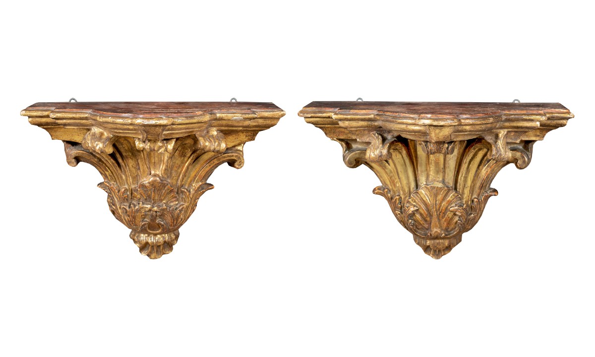 Coppia di mensole a parete in legno intagliato e dorato. Italia, XVIII secolo.