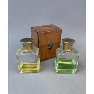 Two Bottles Of Perfume And Their Travel Case